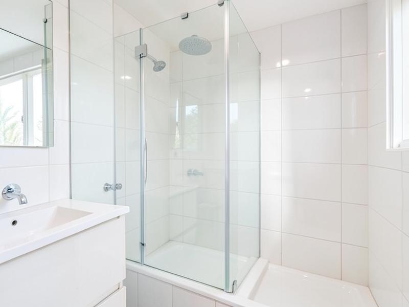 Clean bathroom shower screen and vanity in a rental property
